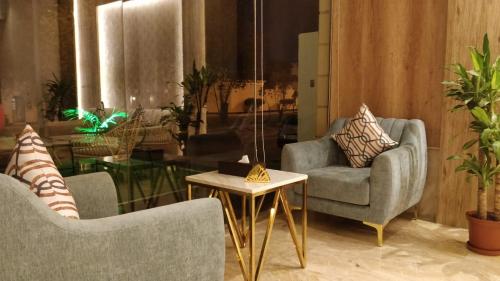 a living room with two chairs and a table at ماس للشقق المخدومة الفاخرة in Jeddah