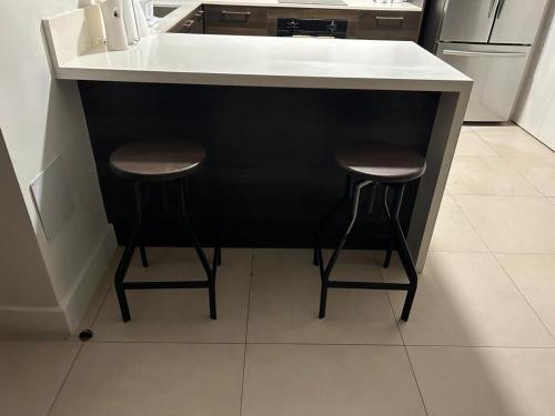a kitchen with two stools at a kitchen counter at Luxury Suite kingston city view in Kingston