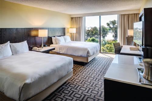 a hotel room with two beds and a television at Hilton Sacramento Arden West in Sacramento
