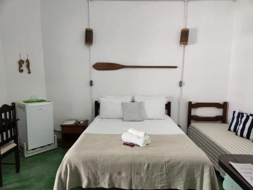 a bedroom with a bed with towels on it at Pousada São Francisco in Cumuruxatiba