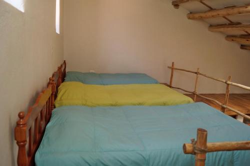 a bedroom with two beds with blue and yellow sheets at Tradicion Colca in Yanque