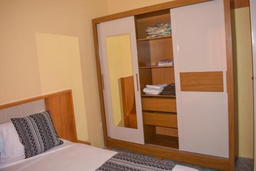 a bedroom with a mirror and a bed and a closet at De Pina Apartments in Pedra Badejo