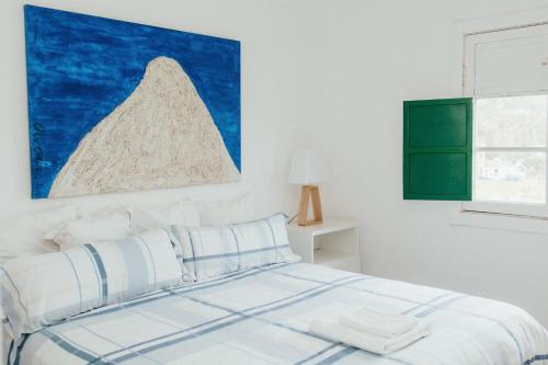 a bedroom with a bed with a painting on the wall at The Sea Corner Vacacional La Palma in Santa Cruz de la Palma
