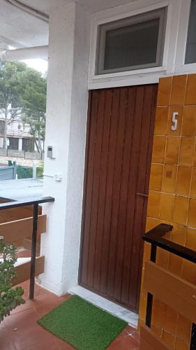 a wooden garage door with a number on it at Estudio en la playa in Molnás