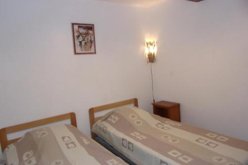 a bedroom with two beds and a light on the wall at DOMAINE LE PLA de LIÉRE in Maury