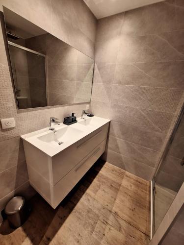 une salle de bain avec un lavabo blanc et un miroir dans l'établissement Superbe T3 vue sur mer parking privé classé 3 étoiles, à Collioure