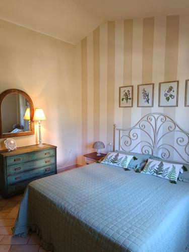 a bedroom with a bed and a dresser and a mirror at Petit Plaisance in Capoliveri