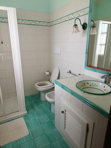 a bathroom with a toilet and a sink and a mirror at Petit Plaisance in Capoliveri