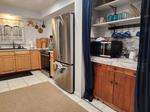a kitchen with a stainless steel refrigerator and wooden cabinets at 3BR Oasis with Pool in Cocoa in Cocoa