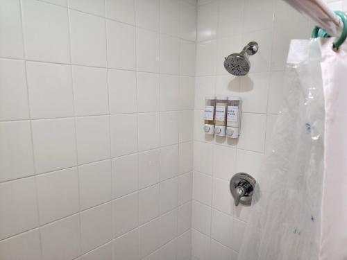 a white tiled shower with a silver shower head at 3BR Oasis with Pool in Cocoa in Cocoa