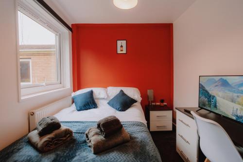 a bedroom with a bed with a red wall at 6-BR - Perfect for Contractors - Long-stay Savings in Sheffield