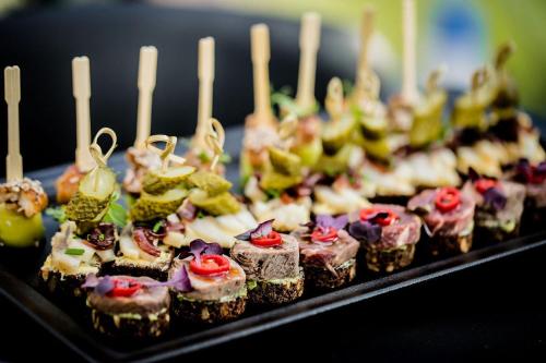 a bunch of cupcakes on a black plate with candles at Salų dvaro kultūros ir laisvalaikio rezidencija in Salos