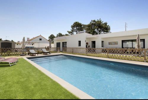 a swimming pool in front of a house at Olive Tree House by DolceStay in Sesimbra
