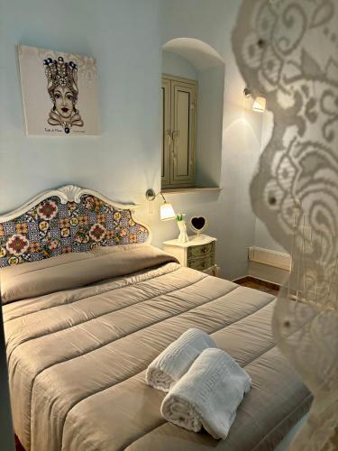 Un dormitorio con una cama grande y un espejo. en Casa A Mori, en Noto