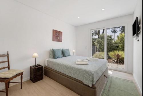 a bedroom with a bed and a large window at Olive Tree House by DolceStay in Sesimbra