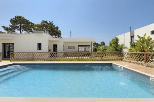a swimming pool in front of a house at Olive Tree House by DolceStay in Sesimbra