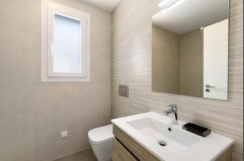 a bathroom with a sink and a toilet and a mirror at Olive Tree House by DolceStay in Sesimbra