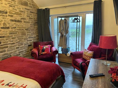 a bedroom with a bed and two chairs at The Coach House & The Stables Yorkshire Peak District With and without hot tub options in Wortley