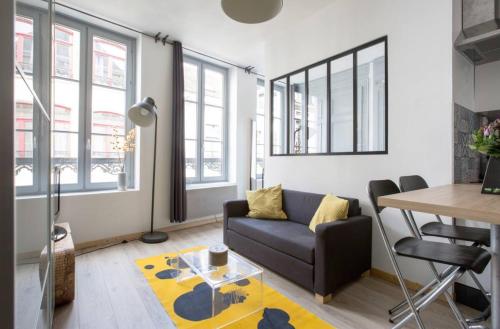 un salon avec un canapé et une table dans l'établissement Charmant Appartement au cœur du Vieux-Lille, à Lille