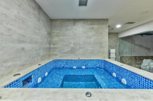 ein großes Badezimmer mit blau gefliester Badewanne in der Unterkunft Heli Zlatibor in Zlatibor