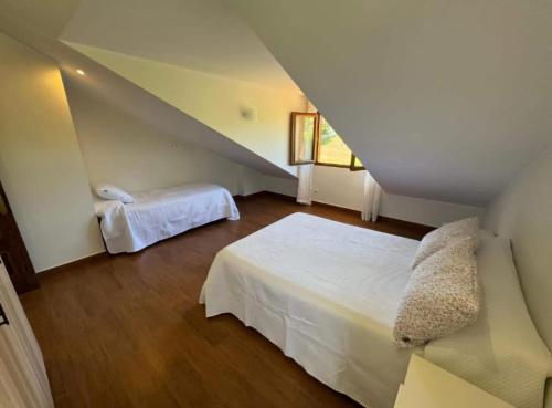 a attic bedroom with a bed and a stair case at Villa Araceli in Suances