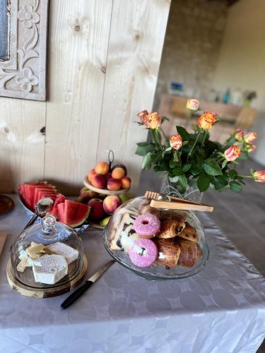 una mesa con un plato de comida y un jarrón con flores en Maison d'hôtes De La Boissière, en Andillac
