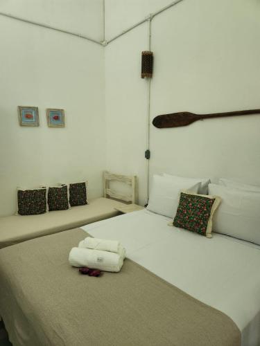 a bedroom with a white bed with towels on it at Pousada São Francisco in Cumuruxatiba