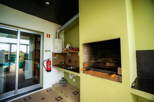 a kitchen with a pizza oven on the wall at Azores Mountain View in Ribeira Grande