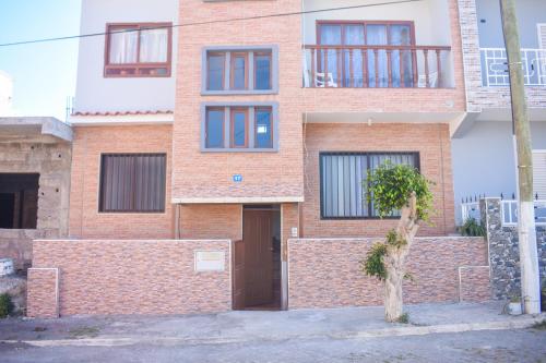 a brick building with a tree in front of it at De Pina Apartments in Pedra Badejo