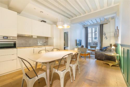 une cuisine et une salle à manger avec une table et des chaises dans l'établissement Strata, à Paris