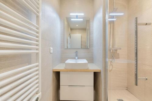 une salle de bain avec un lavabo et une douche dans l'établissement Strata, à Paris