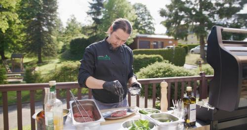 a man is preparing food on a table at Hotel Waldesruh in Lengefeld