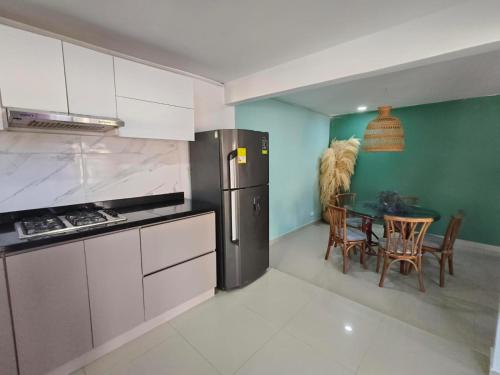 a kitchen with a refrigerator and a table with chairs at Casa Plenitud Lux in Cartagena de Indias