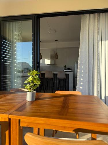 a dining room table with chairs and a kitchen at Equinox Appartment in La Gaulette