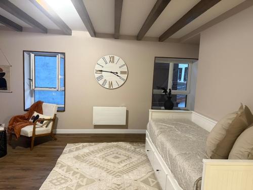 une chambre avec un lit et une horloge au mur dans l'établissement Un studio a deux pas de lautoroute, à Domarin