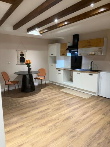 une cuisine et une salle à manger avec une table et des chaises dans l'établissement Un studio a deux pas de lautoroute, à Domarin