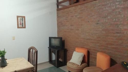 a living room with a tv and a table and chairs at Hermosa Casita II Paso Patria in Paso de la Patria
