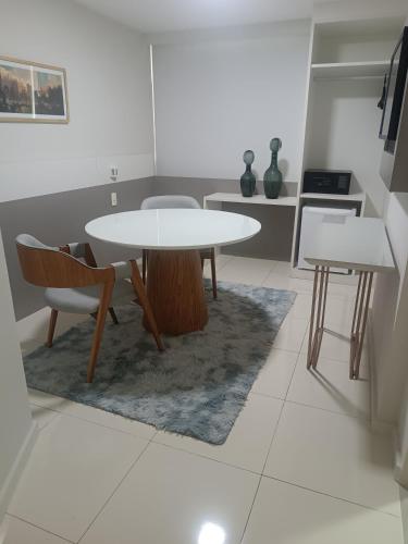 a dining room with a table and chairs and a kitchen at Trip Hotel Ubá - perto da Faculdade OZANAM COELHO e Eventos HORTO FLORESTAL in Ubá