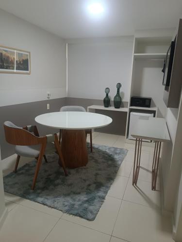 a white table and chairs in a room with a kitchen at Trip Hotel Ubá - perto da Faculdade OZANAM COELHO e Eventos HORTO FLORESTAL in Ubá