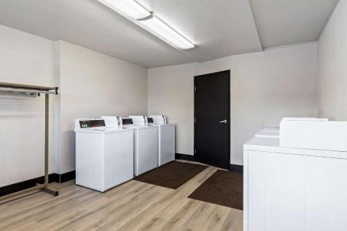 an empty room with white walls and a black door at SureStay Hotel by Best Western Phoenix Airport in Phoenix