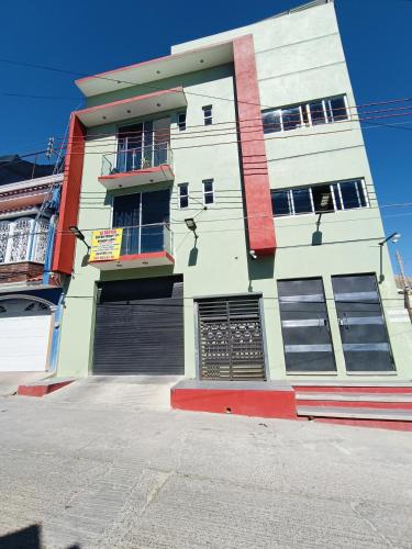 a white and red building with a garage at Departamento Bien Bonitío 1 in Comitán de Domínguez