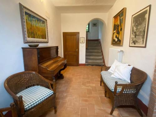 a living room with a piano and a chair at Casa per 9 con giardino vicino al Monte Amiata e alla Val d'Orcia in Arcidosso