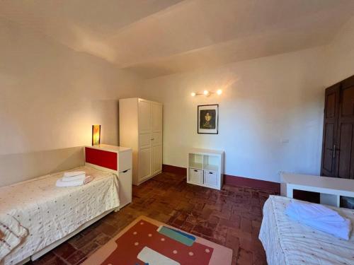 a bedroom with two beds and a dresser at Casa per 9 con giardino vicino al Monte Amiata e alla Val d'Orcia in Arcidosso