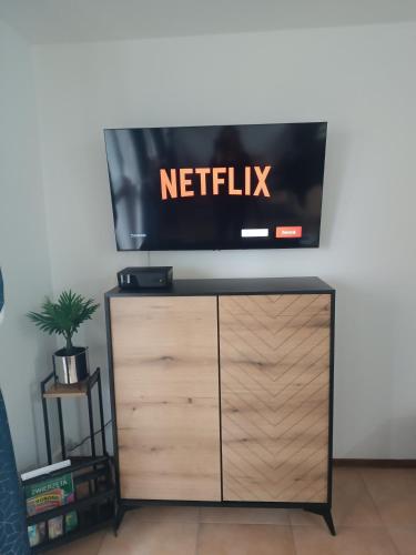 a flat screen tv on top of a dresser at Cosy Space Apartment in Tychy