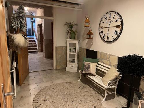 a living room with a clock on the wall and a couch at Endbach-Life in Bad Endbach