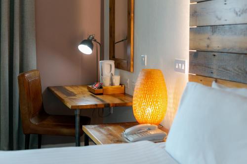 a bedroom with a desk with a lamp and a phone at Cedar Court Bradford Hotel in Bradford
