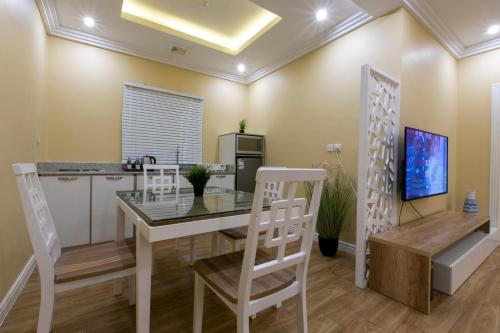 a dining room with a table and chairs and a tv at ماس للشقق المخدومة الفاخرة in Jeddah