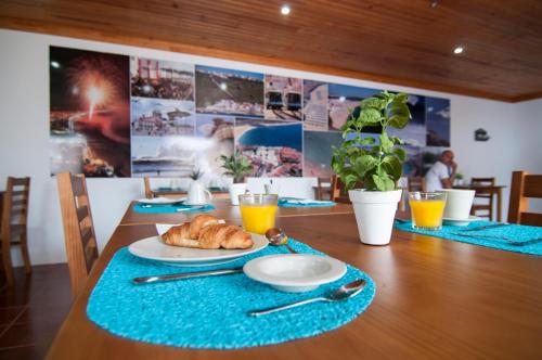 a table with a croissant and a plate of food at NorthSpot in Nazaré