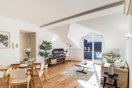 a living room with a table and a couch at Bright stylish gem in central Melbourne in Melbourne