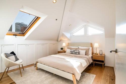 a white bedroom with a bed and a window at Bright stylish gem in central Melbourne in Melbourne